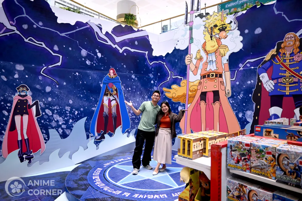 Fã posando com estátuas de personagens de One Piece